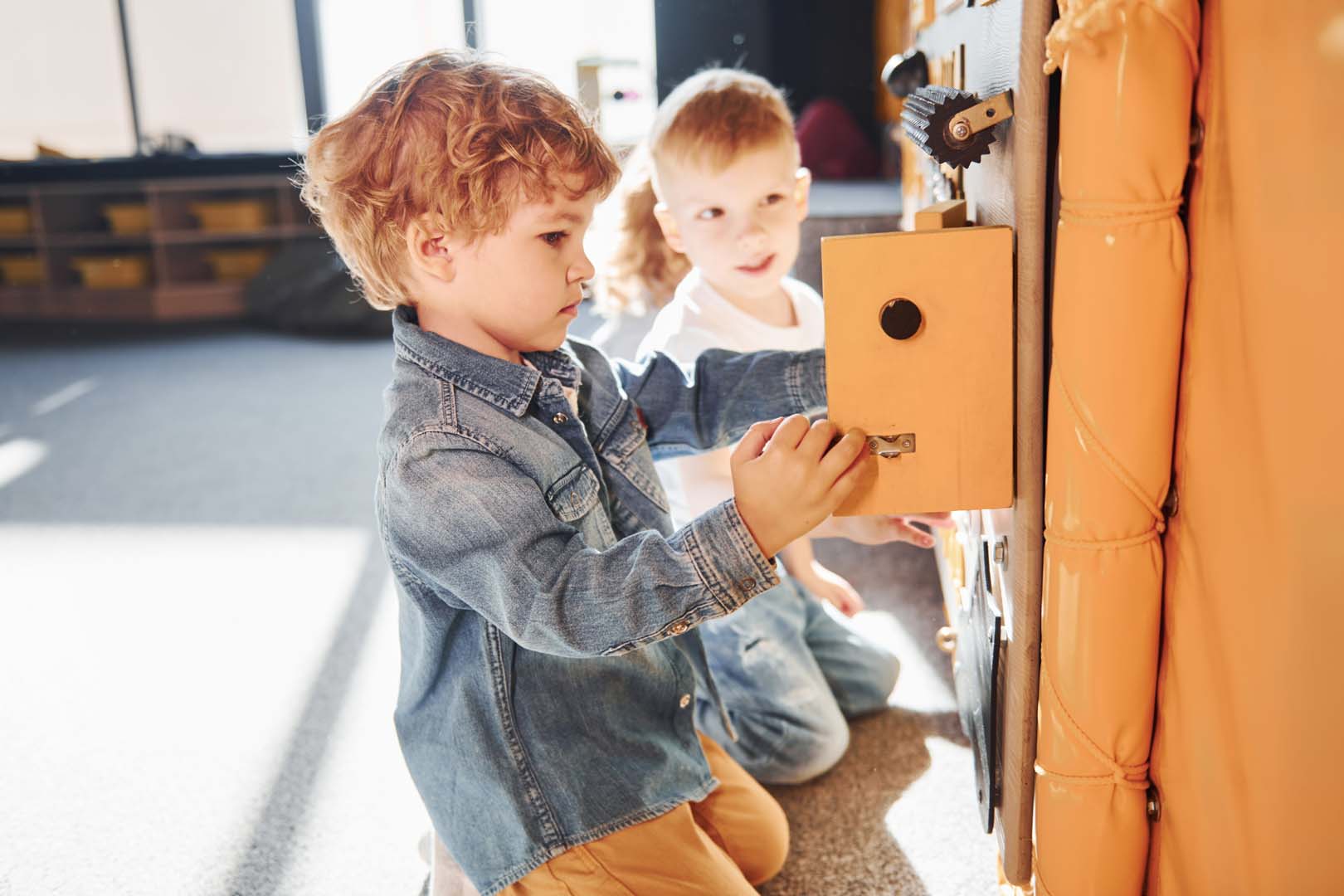 Children have fun in playroom near the wall. Kindergarten educational games.